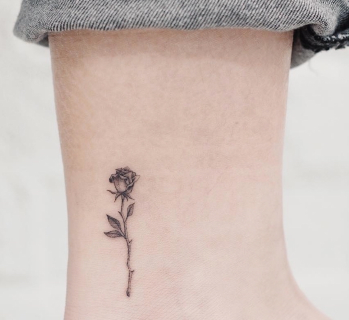 pequeña rosa tatuada en el tobillo, tatuajes minimalistas con fuerte significado, significado de los tattoos con flores 