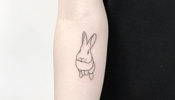tattoo con el conejo del libro ¨Alisia en el pasís de las maravillas¨, ideas de tatuajes inspirados en libros y películas 
