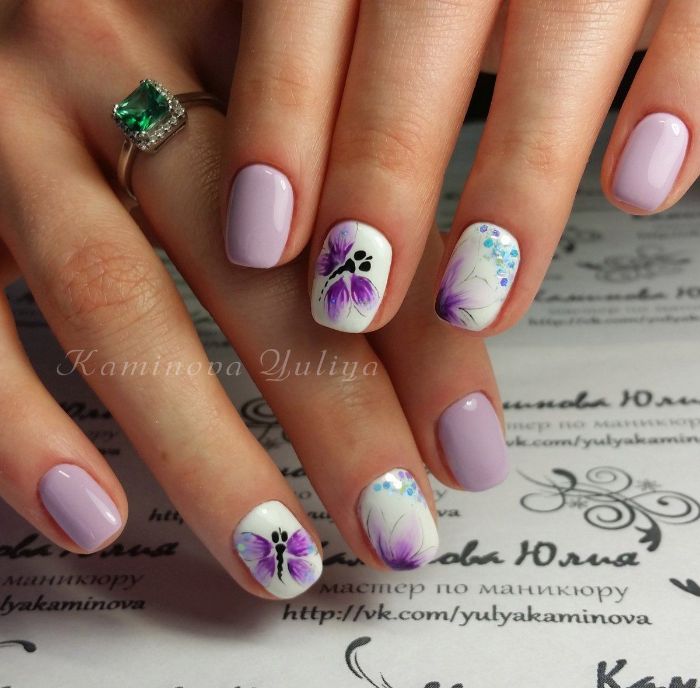 los mejores ejemplos de dibujos en uñas, uñas cortas pintadas en color lila y blanco con hermosos dibujos de mariposas 
