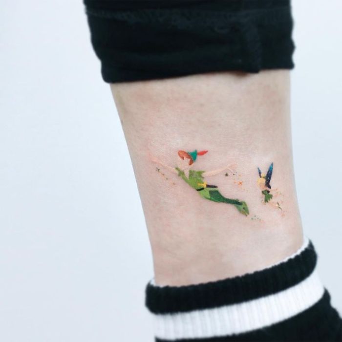 tatuaje peter pan en el tobillo, originales ideas de tatuajes minimalistas con personajes de Disney, pequeños tattoos en colores 