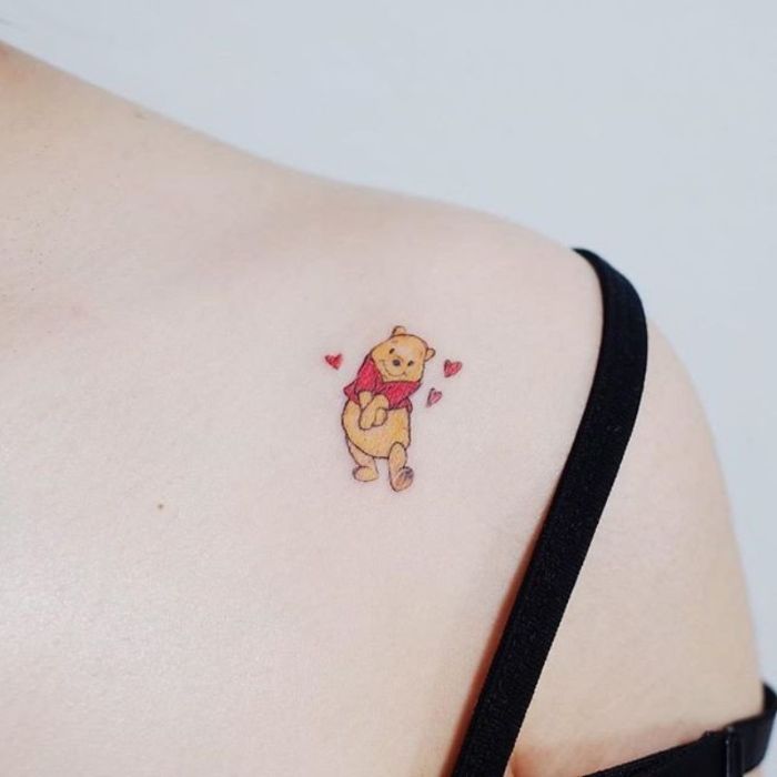 tatuajes diseny pequeños, diseños coloridos de tatuajes originales, tatuaje el Oso Pooh pequeño en el hombro, diseños de tatuajes divertidos 