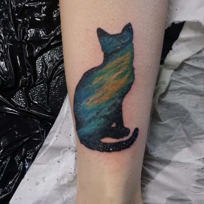 tatuaje gato con acuarela, diseños de tatuajes en acuarelas, tatuaje gato en negro, azul y amarillo, diseños de tatuajes en la pierna 