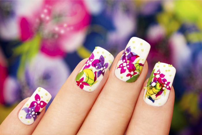 uñas de gel decoradas con preciosos dibujos de motivos florales, uñas largas pintadas en blanco con dibujos en colores vibrantes 