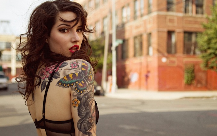 mujer con grande tatuaje en el brazo con mariposa y motivos florales, fotos de tatuajes en estilo old school, diseños de tattoos 