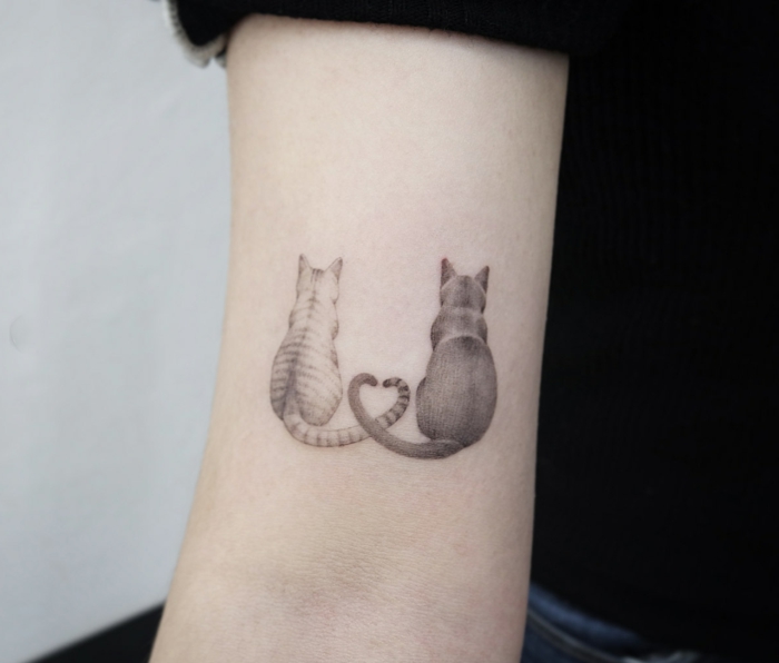 hermoso tatuaje de gatos con colas entrelazadas, diseños de tattoos en blanco y negro, tatuajes simbólicos en fotos 