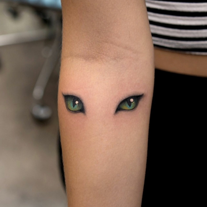 qué significa tener un tatuaje con ojos de gato, huellas de gato y ojos tatuados en el antebrazo, diseños de tatuajes 