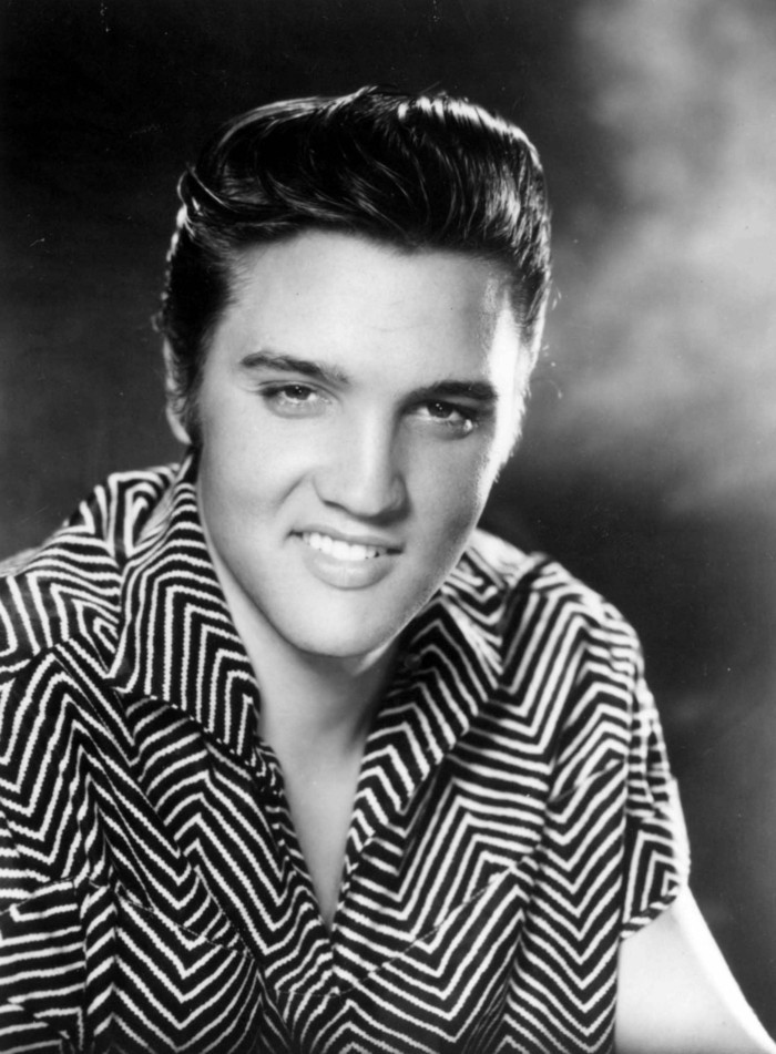 Elvis Presley en un look icónico, camisa en rayas blanco y negro y su famoso peinado con tupé, peinados hombre vintage 