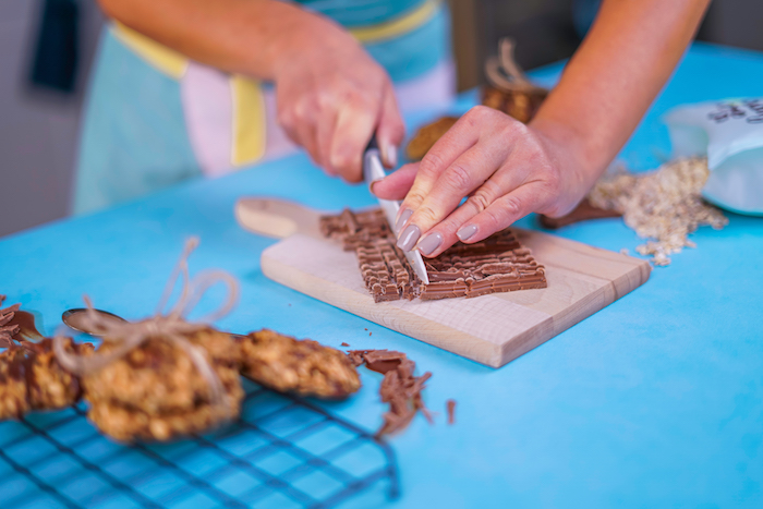cortar los trozos de chocolate y añadir los copos de avena para hacer unas galletas de avena ricas y saludables, recetas de galletas