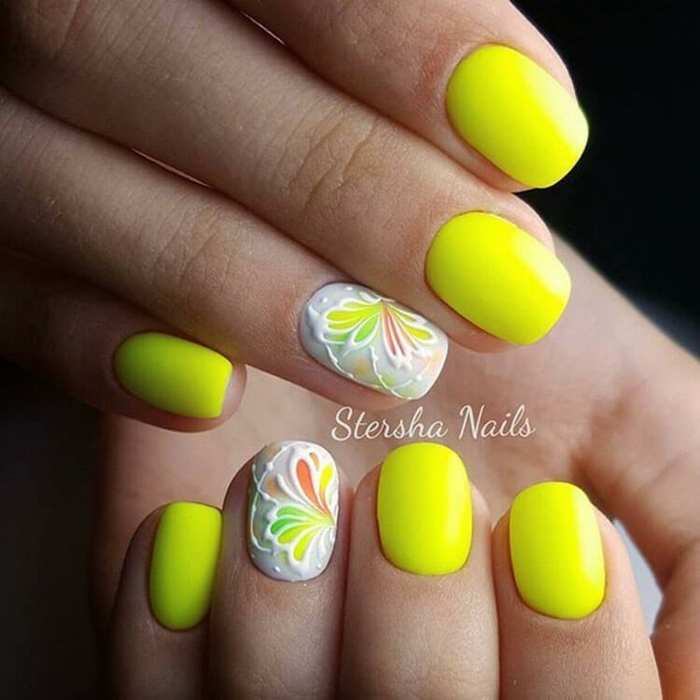 colores neón en las uñas, uñas cortas pintadas en amarillo neón con dibujos de flores, decoración de uñas con motivos florales 