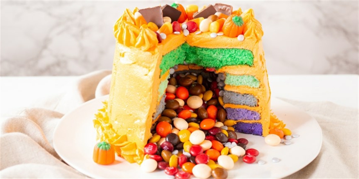 tarta sorpresa llena de caramelos coloridos, recetas divertidas para Halloween, más de 100 ideas de recetas para el otoño 