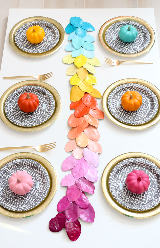 coloridas ideas sobre como vestir la casa en otoño, centro de mesa con hojas de otoño pintadas en los colores del arco iris 