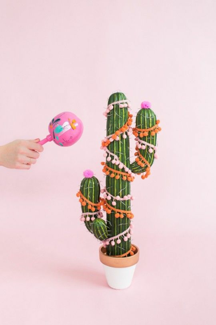 decoración minimalista con un cactus decorado cinta colorida con pequeños pompones, rboles de navidad originales caseros