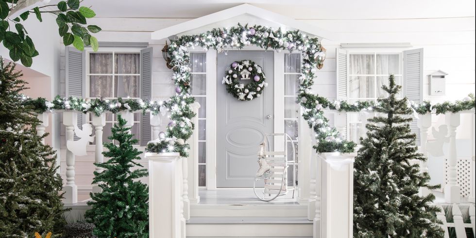 ideas sobre como decorar el porche en Navidad, decoración en blanco y gris y guirnalda verde con bolas en lila y blanco 