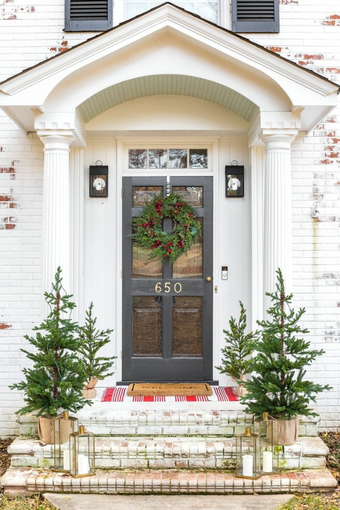 porche decorado con mucho estilo, grande corona verde en la puerta, entradas y puertas decoradas para Navidad