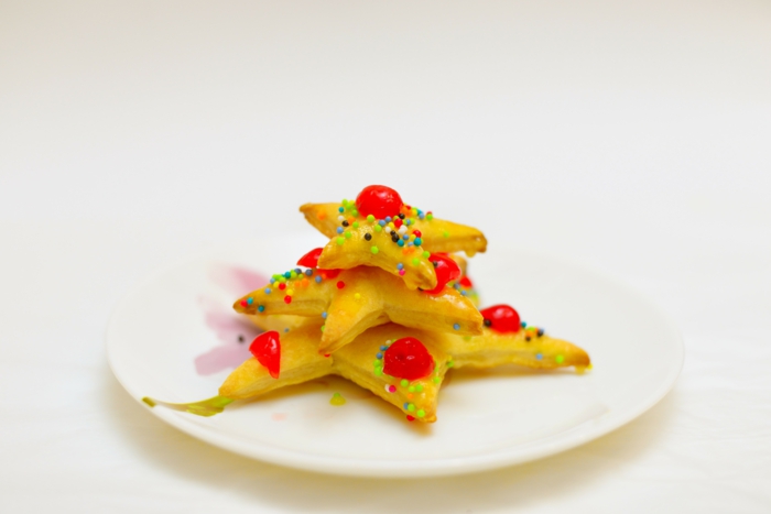 mini árbol de hojaldre con frutas azucaradas, pequeñas galletas en forma de estrella con bolas de azucar decorativas 