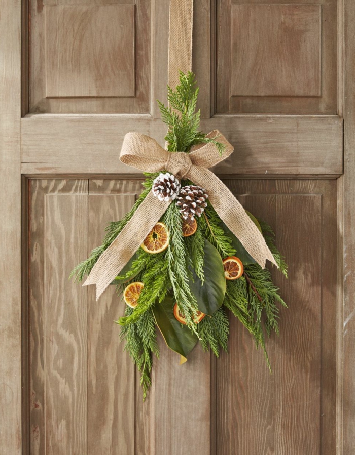 detalle decorativo en estilo rústico, ramas de pino, piñas y cinta de lino en color beige, fotos con ideas sobre como decorar la casa en navidad 