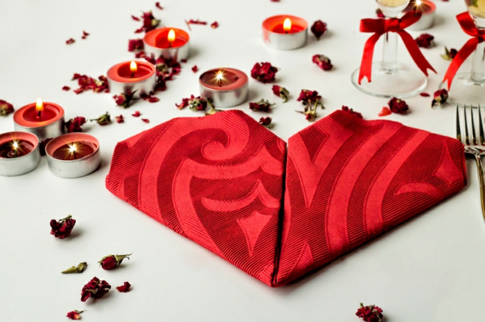 como doblar servilletas de papel para navidad y otras fiestas, servilleta de tela en color rojo doblada en forma de corazón