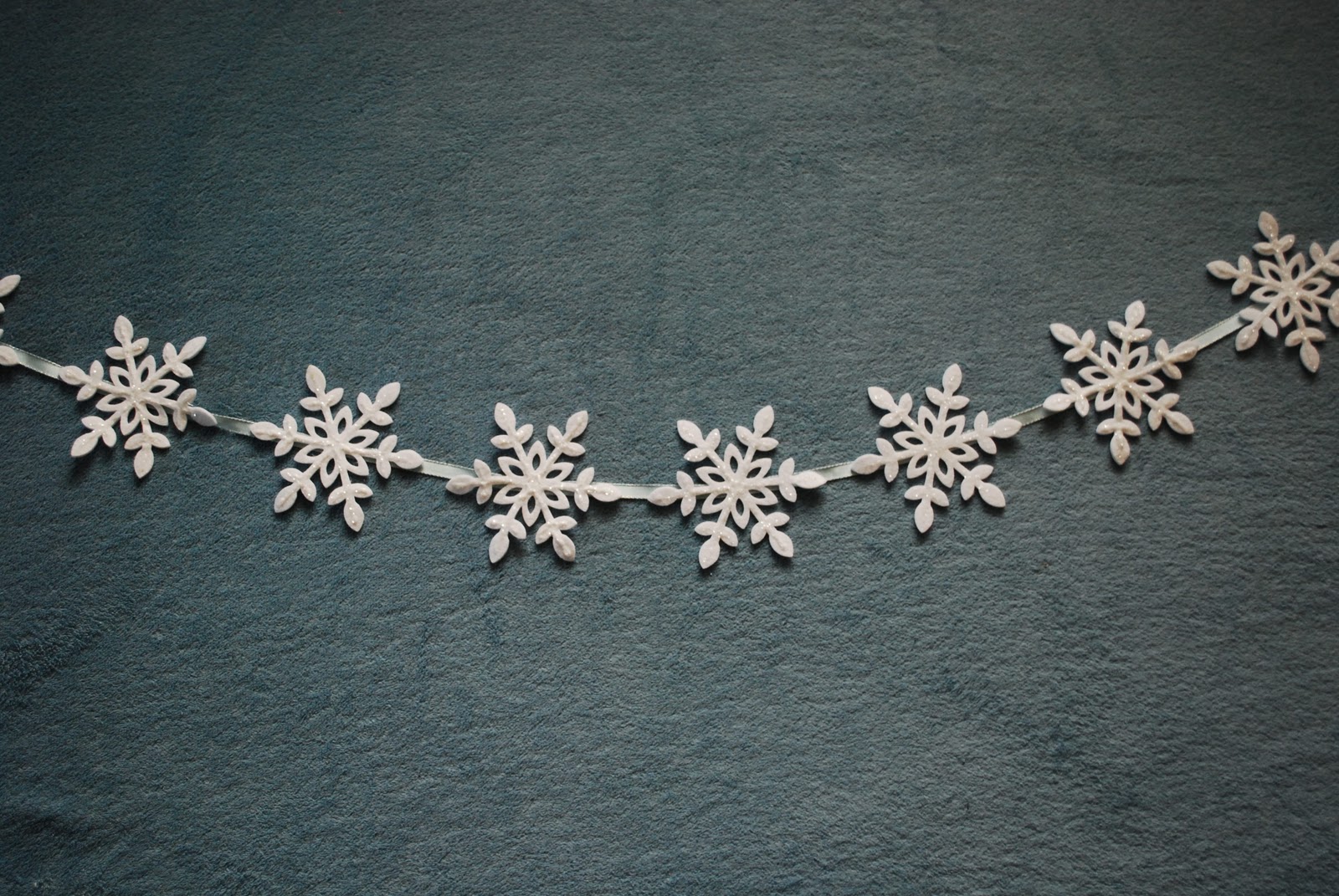 tendencias en la decoración y guirnaldas navideñas caseras, como hacer una guirnalda DIY de copos de nieve de fieltro 