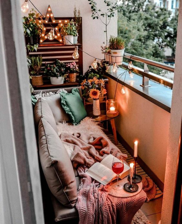 cuartos tumblr decorados con mucho encanto, terraza pequeña con cojines pequeños, velas decorativas y plantas verdes 