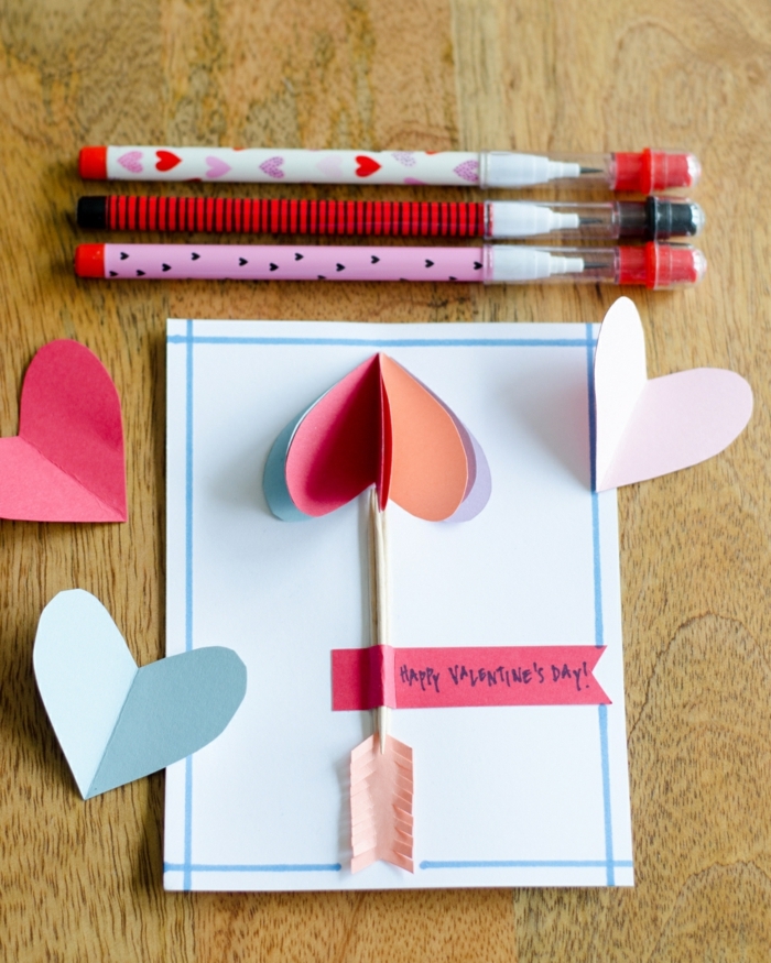 flecha de cúpido hecha con corazones de papel colorida, las ideas más originales de tarjetas de san valentin en fotos 
