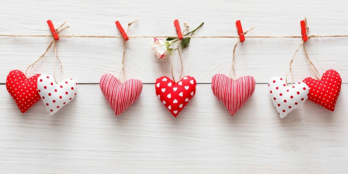 pequeños detalles en forma de corazon colgados a una cuerda, bonitos corazones pequeños en blanco y rojo para decorar la pared 
