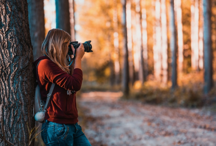 mujer tomando fotografias en un bosque en otoño, preciosos ejemplos de imagenes de reflexion que puedes contemplar para sentirte mejor