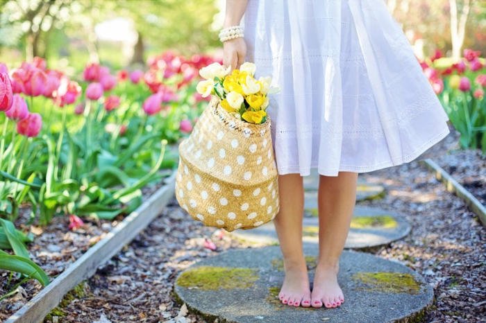 niña descalza con cesta de flores en primavera, paisajes bonitos del mundo, jardin con tulipanes grandes en color rojo 