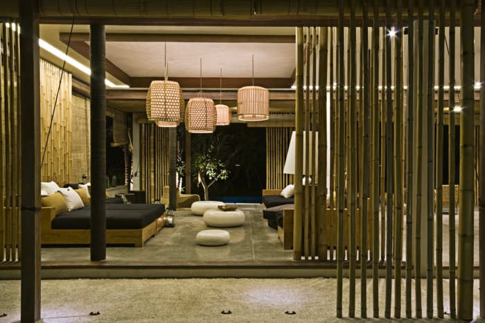 espacio decorado en tonos terrestres con muebles funcionales y modernos, separador de ambientes hecho de bambu 