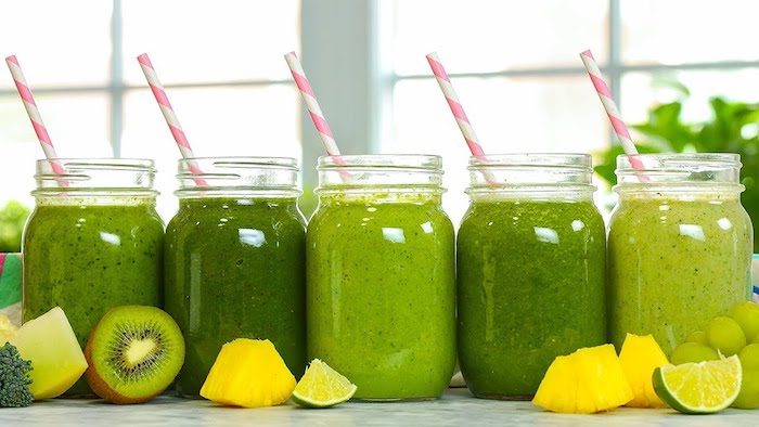 frascos llenos de batido verde de kiwi, lima, uvas, brocoli, como hacer un smoothie de frutas ligero y nutritivo