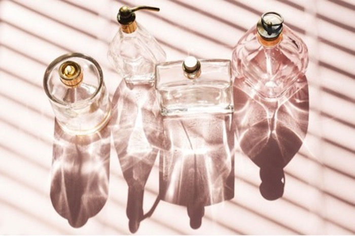cómo elegir el mejor perfume perfumes en frascos transparentes sobre fondo rosa pálido