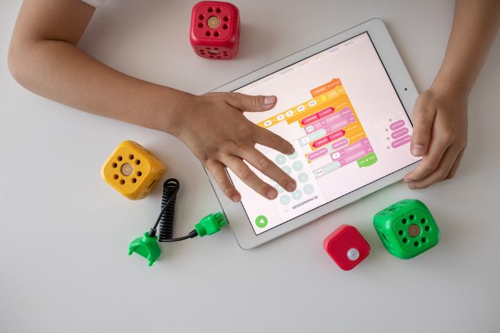 cubos verdes para juegos para niños tableta fondo blanco manos de un niño