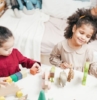dos niños niñas que juegan con juguetes de madera en una sala de juegos