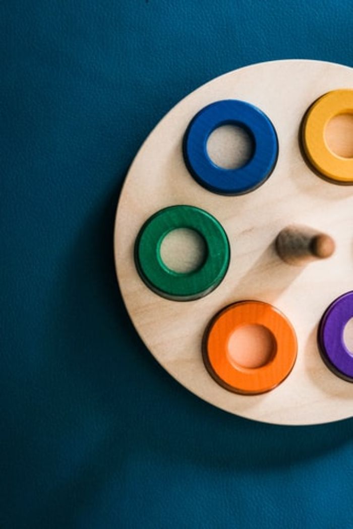 juguete de madera para niños con círculos de madera de colores sobre fondo azul