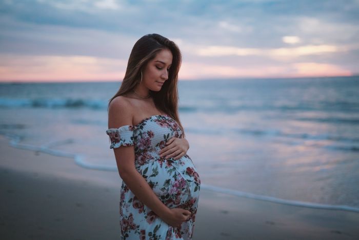 niña embarazada en la playa vestido de flores para embarazada
