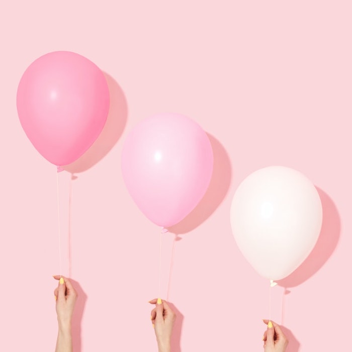 tres globos rosas sobre fondo rosa