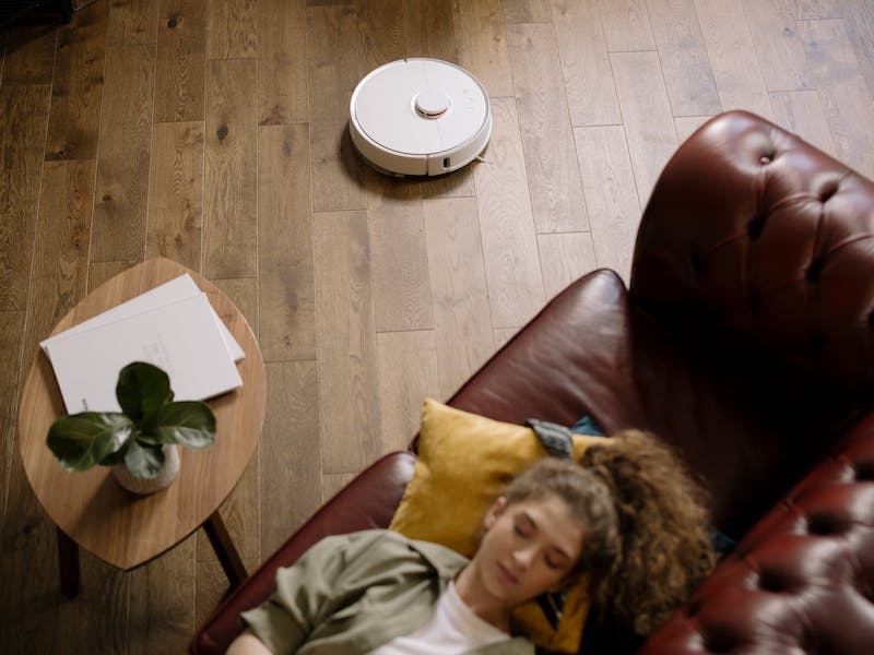 aspiradora robot niña acostada en un sofa de cuero