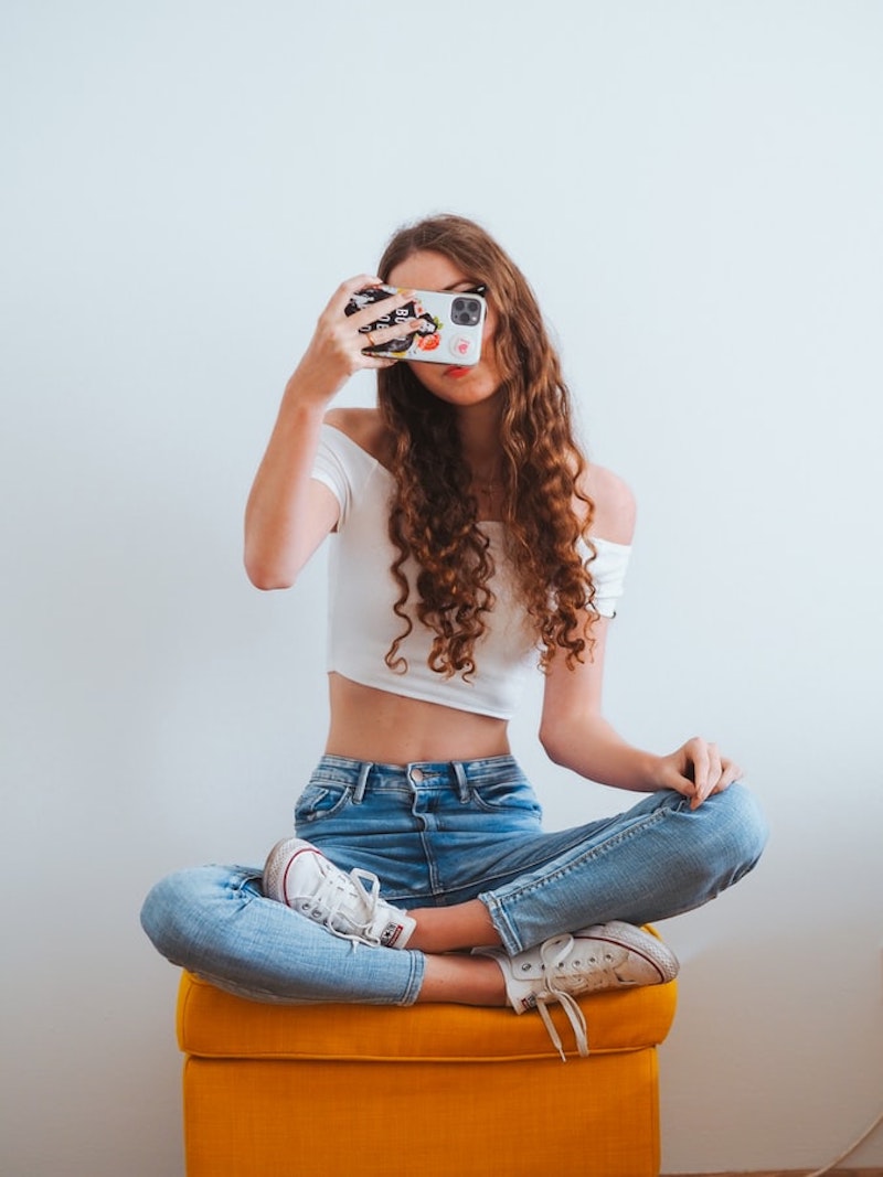 chica con pelo rizado jeans top blanco