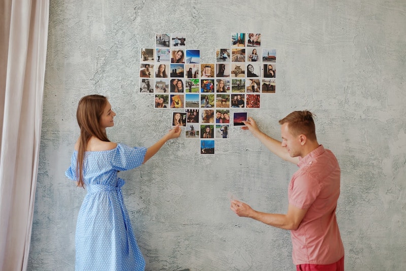 hombre y mujer sosteniendo un marco para fotos en forma de corazon