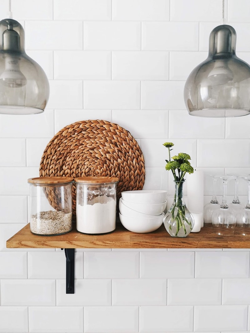 azulejos blancos en la cocina brillante con estante de madera para la cocina especias