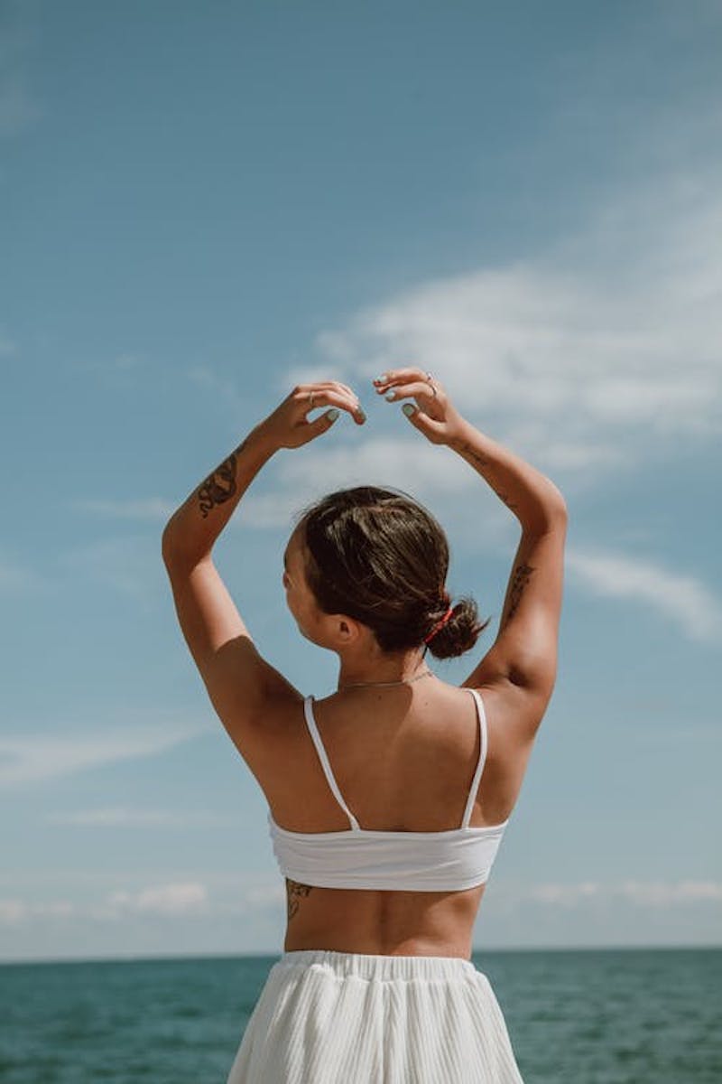 foto de una chica fotografiada contra el mar de espalda con un sujetador deportivo blanco