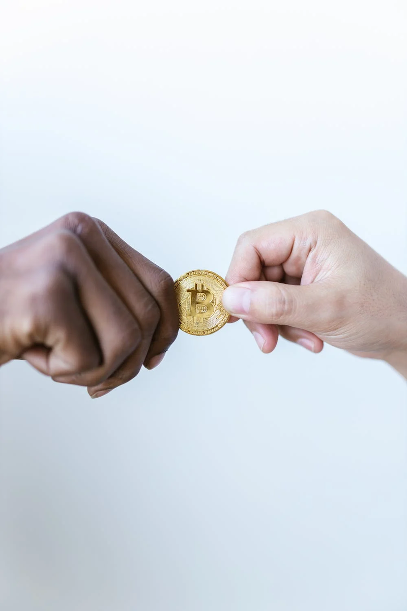 dos manos sosteniendo una moneda bitcoin