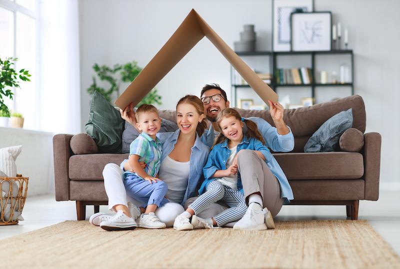 familia feliz sentada en el suelo en la sala de estar