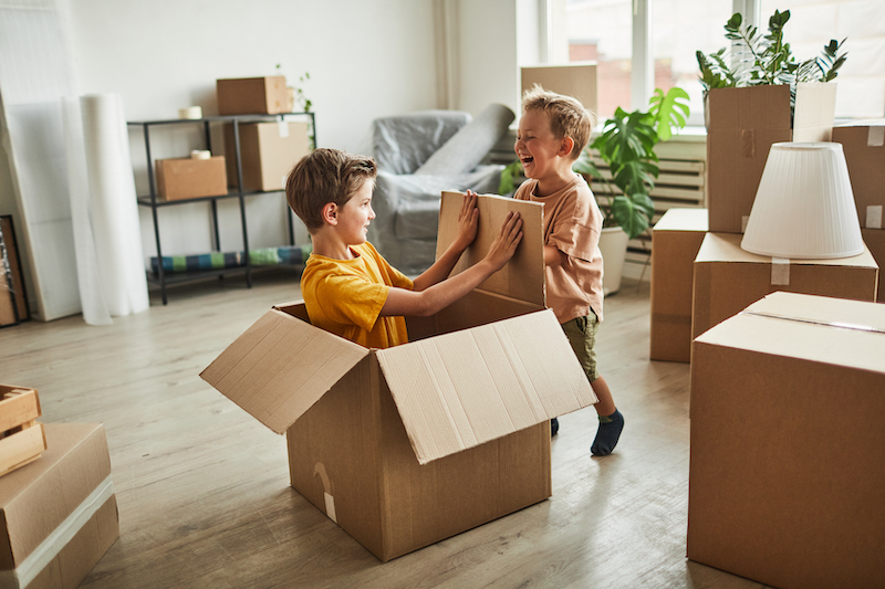 boys playing with boxes in new home