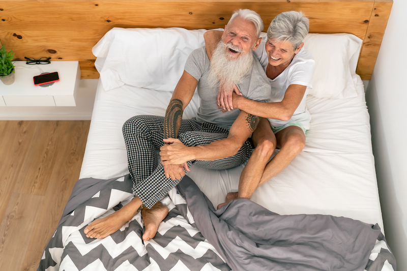 happy senior couple smiling together in bed hipster mature people having tender moments in bedroom elderly lifestyle and love relationship concept