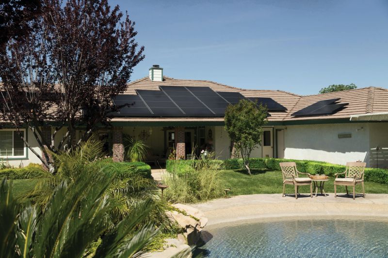 casa con paneles solares gran césped verde y vegetación verde