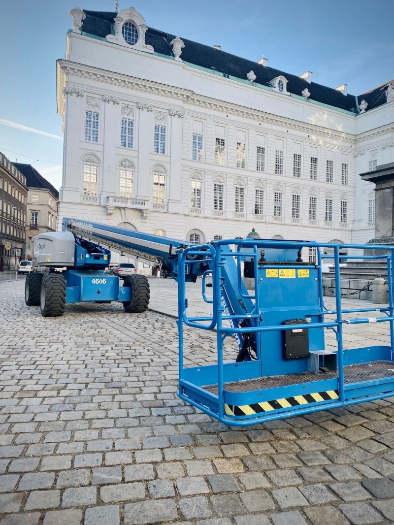 tractor azul con plataforma elevadora fotografiada en una plaza