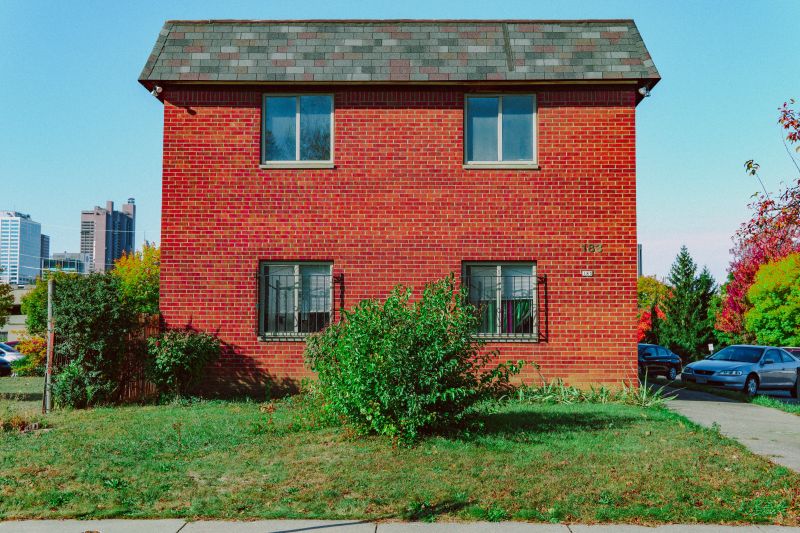 una casa con fachada de ladrillo y un gran césped verde en el patio