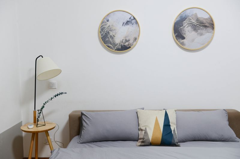 moderno salón amueblado con sofá gris y cuadros redondos en la pared