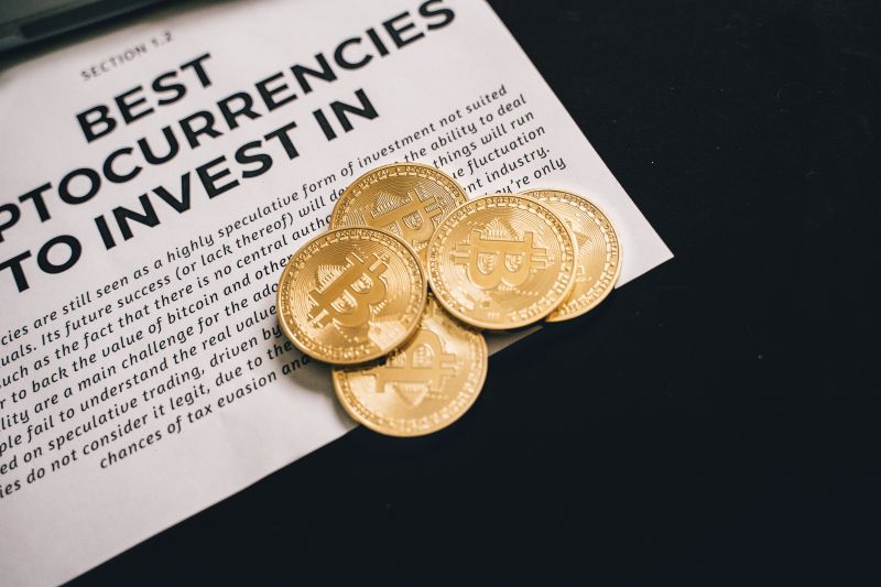 periódico con monedas bitcoin fotografiado sobre fondo negro