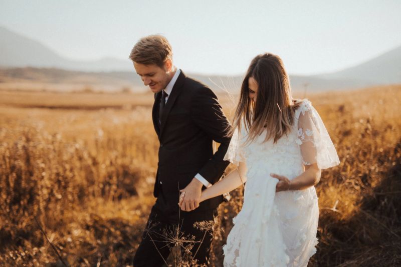foto de recién casados paseando por un campo de trigo